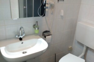 Das Badezimmer ist ausgestattet mit Föhn und Kosmetikspiegel. Badezimmer Waschbecken Spiegel